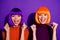 Close-up portrait of two nice attractive lovely pretty cheerful cheery glad girls wearing wigs holding fists celebrating