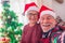 Close up and portrait of two pensioners and senior looking at the camera smiling and enjoying taking a selfie the christmas day at