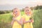 Close-up portrait of two preschool girls in yellow dresses in nature,