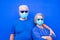 Close up and portrait of two seniors and mature people together wearing blue clothes and medical and surgical mask to prevent