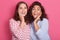 Close up portrait of two stupefied young adorable women stand closely to each other, keeping open mouths widely, girls posing over