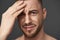 Close up portrait of upset bearded young man posing in studio