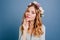 Close-up portrait of white dreamy girl with shiny wavy hair. Studio shot of positive young lady in wreath isolated on