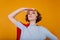 Close-up portrait of winsome girl in blue shirt standing in confident pose on yellow background. Brave female model in