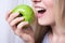 Close up portrait of woman biting green apple