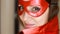 Close up portrait woman superhero. Girl in a red raincoat and mask playing power super hero. Superhero and power concept