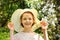 Close-up portrait of woman wearing straw hat enjoying summer sun. Pattern of shadows falling on her face