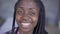 Close-up portrait of young African American woman with afro pigtails looking at camera smiling. The girl with problem