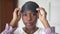 Close-up portrait of young African American woman taking off sleeping eye mask looking at camera. Beautiful charming