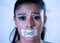 Close up portrait of young attractive latin woman with mouth sealed on stick tape with text no food in diet Anorexia eating