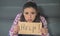 Close up portrait of young attractive and sad hispanic woman sitting at home couch looking stressed and worried showing help sign