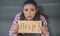 Close up portrait of young attractive and sad hispanic woman sitting at home couch looking stressed and worried showing help sign