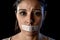 Close up portrait of young attractive woman with mouth and lips sealed in adhesive tape restrained