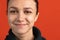 Close-up portrait of young bautiful caucasian girl isolated over red studio background. Smiling