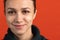 Close-up portrait of young bautiful caucasian girl isolated over red studio background. Tender smile