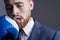 Close-up portrait of a young bearded guy in a business suit, businessman, side view the hand of an opponent in a boxing glove