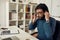 Close up portrait of young bearded male teacher adjusting wireless headphones while giving online class through webcam