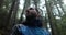 Close-up portrait of a young bearded man sitting in nature between forest