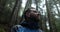 Close-up portrait of a young bearded man sitting in nature between forest