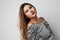 Close-up portrait of young beatiful woman wearing silver dress and posing at white empty studio background. Copy Space