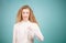 Close up Portrait of young beautiful female in white blouse pointing at herself