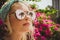 Close-up portrait of a young beautiful girl in glasses with reflection of tropical palms. Summer rest. Modern tourist