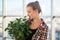 Close-up portrait of a young beautiful woman, holding decorative plant, smiling, looking at camera