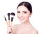 Close up portrait of young beautiful woman with make up brushes