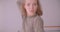 Close-up portrait of young caucasian professional ballerina dancing being pretty and concentrated in light studio.