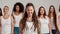 Close up portrait of young caucasian tattooed woman with dreadlocks in white shirt smiling at camera. Group of diverse