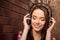 Close up portrait of young cheerful girl listening music with headphones