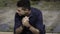 Close up portrait of a young classy businessman sitting alone near the Lisbon riverside. Elegant freelance architect sitting on