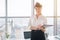 Close-up portrait of a young confident female office manager at her workplace, ready for doing business task.