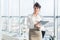 Close-up portrait of a young confident female office manager at her workplace, ready for doing business task.