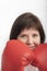 Close-up portrait of young dark-haired woman in red wrestling gloves. Woman boxer. Vertical frame