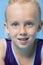 Close-up portrait of a young female gymnast over blue background