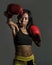 Close up portrait of young fit Asian Chinese woman in fitness top and boxing gloves throwing punch in bad girl attitude angry and