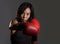 Close up portrait of young fit Asian Chinese woman in fitness top and boxing gloves throwing punch in bad girl attitude angry and