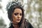 close up portrait of a young girl in the image of the black queen witch in a black crown tiara