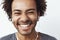 Close up portrait of young happy african man smiling listening to upbeat streaming music laughing over white background