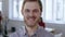 Close-up portrait of young happy European finance businessman cheerfully smiling at camera in modern office workplace.