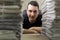 Close up portrait of a young journalist and a stacks of newspapers in blurred foreground