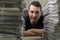 Close up portrait of a young journalist and a stacks of newspapers in blurred foreground