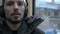 Close up portrait Young long haired bearded man in a jacket and large headphones sits in public transport by the tram by