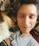 Close-up portrait of young man sleeping with dog. Cute Welsh Corgi puppy resting with owner on couch