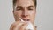 Close up portrait of young man wiping his bleeding nose with tissue, slow motion