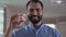 Close-up portrait of young Middle Eastern man holding teeth cast and smiling at camera. Professional orthodontist posing