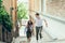 Close-up portrait of the young pretty loving couple holding hands while going up the stairs in the narrow Budapest