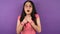 Close-up portrait of young suddenly frightened hipster Asian woman on isolated purple background. A woman in fashionable