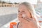 Close-up portrait of a young sweet and happy teenage girl smearing sunscreen on her face